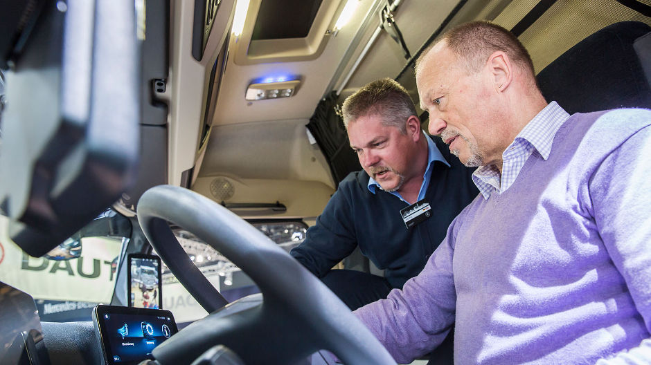 RoadStars-kuljettaja Manfred Wandl (oikealla) kuuntelee, kun myyjä Olaf Broy kertoo Multimedia cockpitin toiminnoista.