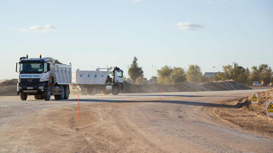 Onophoudelijk rijden de trucks en bouwmachines af en aan – voor de veiligheid regelen wegwerkers het verkeer. 