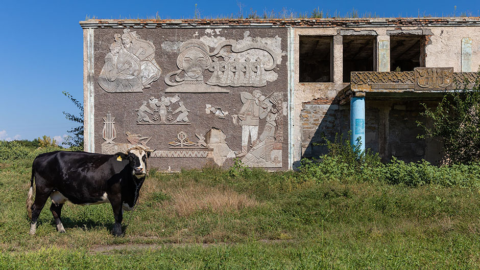 Steeds weer duiken er verlaten gebouwen uit het Sovjettijdperk langs de rand van de weg op.