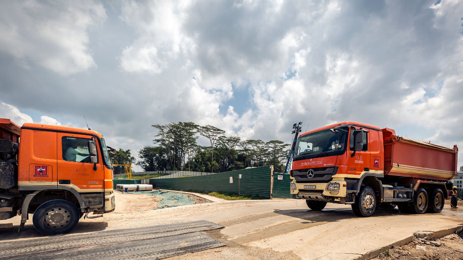Abfahrt im Zwei-Minuten-Takt. Mit mehr als 100 Actros des Typs 3336 trägt Huationg Global Limited Erdreich von Hügeln in Singapurs Zentrum ab, um es zur Verfestigung von Baugrund zu verwenden, der zuvor dem Meer abgerungen wurde.