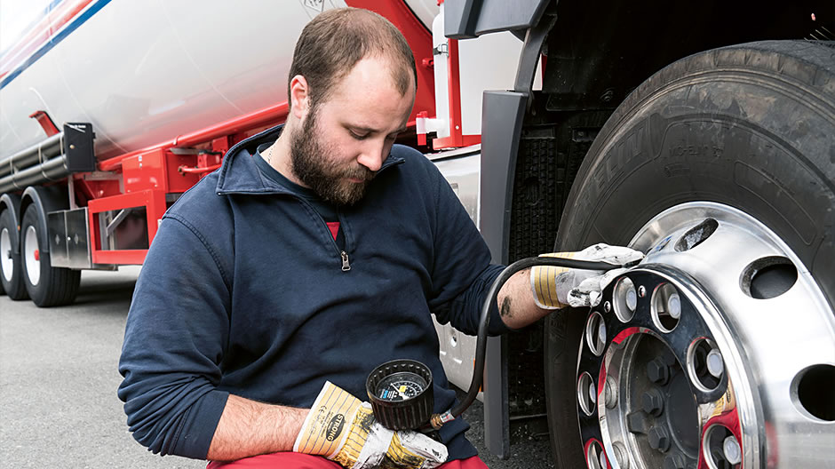 Speedy aid. After the message in the display of his Actros, driver Jan Hettling checks the tyre pressure on the front axle. In the background, Mercedes-Benz Uptime fleet manager Sascha Schmieder supplies all the details about the loss of pressure via the online customer portal.