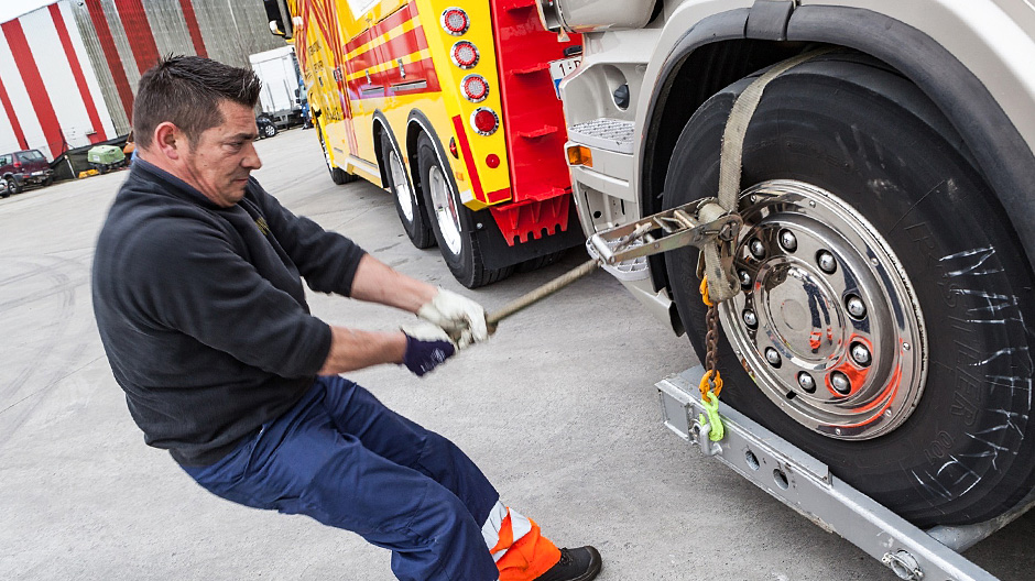 Accrochez ! Erik Pernet, chauffeur chez HSD, démontre comment il fixe les roues avant du camion à remorquer.