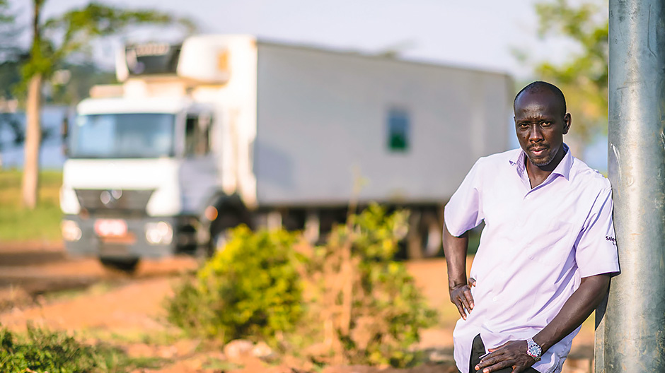 Robuust en betrouwbaar. Chauffeur Peter Muwanga, hier tijdens een pauze aan de oever van het Victoriameer, kan vertrouwen op zijn Axor 1823 met koelopbouw van Carrier. Zijn werkgever, Wagagai Farm, waardeert zijn chauffeursvaardigheden.