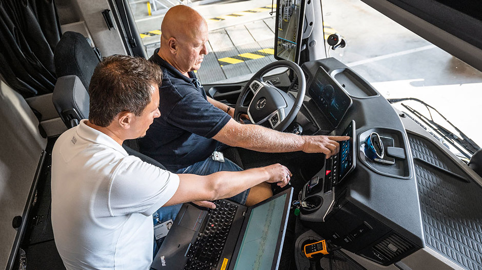 Intuitive Bedienbarkeit. Testfahrer Markus Wolf und Entwicklungsingenieur Matthias Lang gehen die Menüs des Multimedia Cockpits durch, bevor sie den neuen Actros auf der Straße testen.  